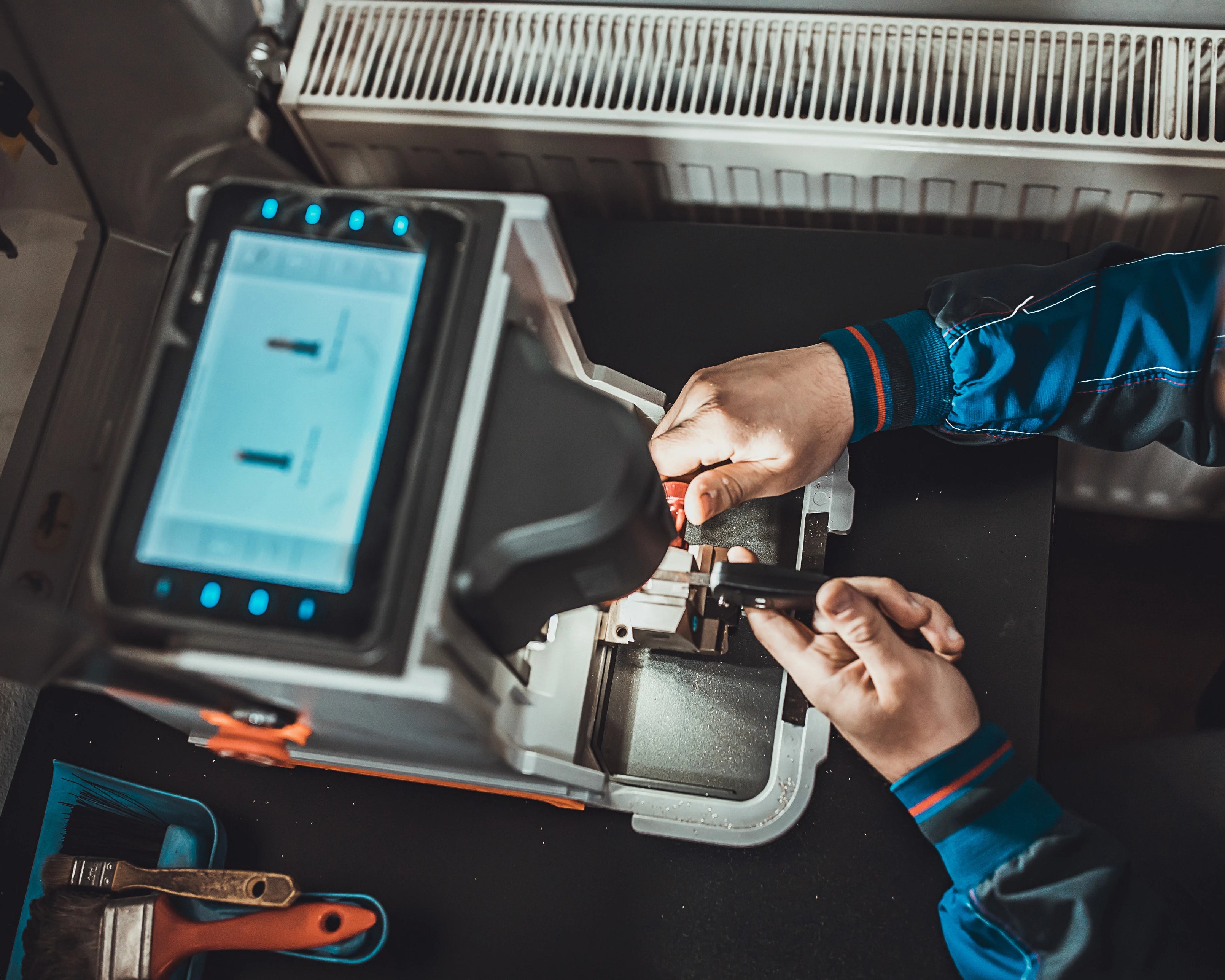 artisan qui fait un double de clés sur une machine dans l'atelier