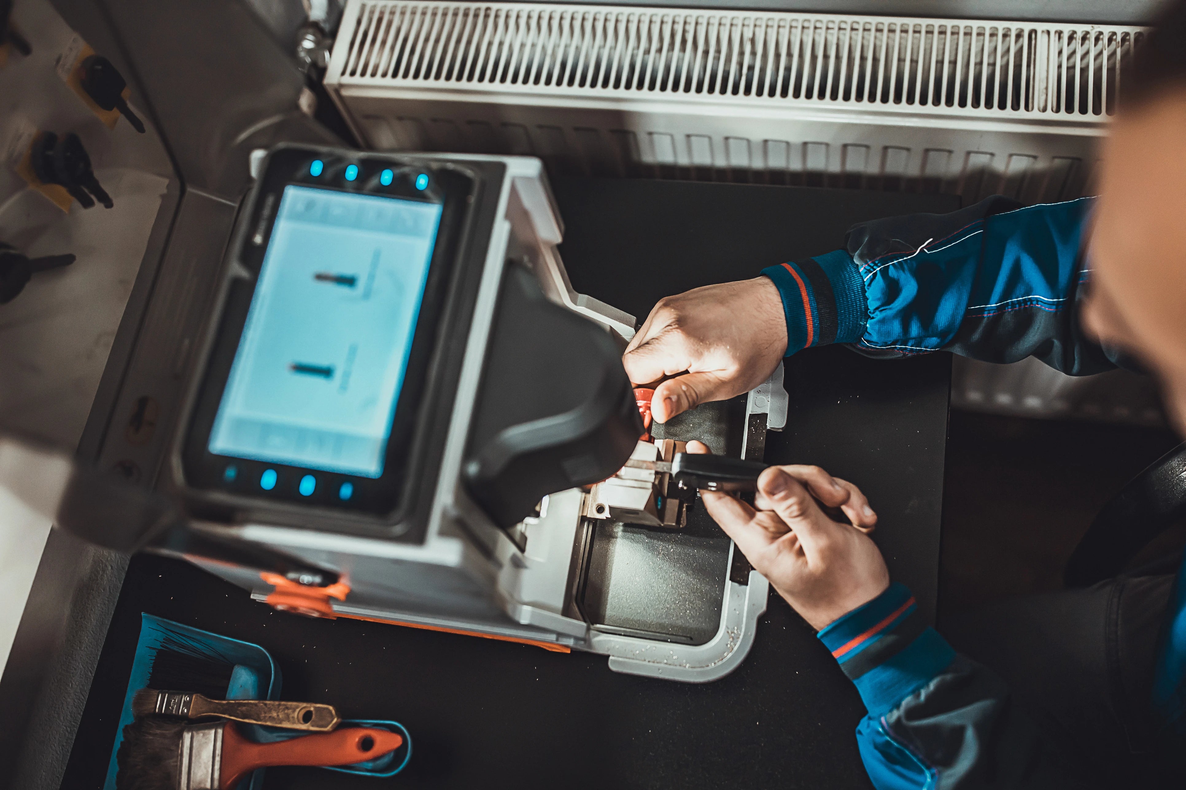 artisan qui fait un double de clés sur une machine dans l'atelier